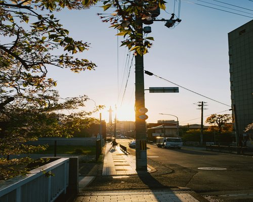A person taking a calm walk on a urban pedestrian path during morning golden hour